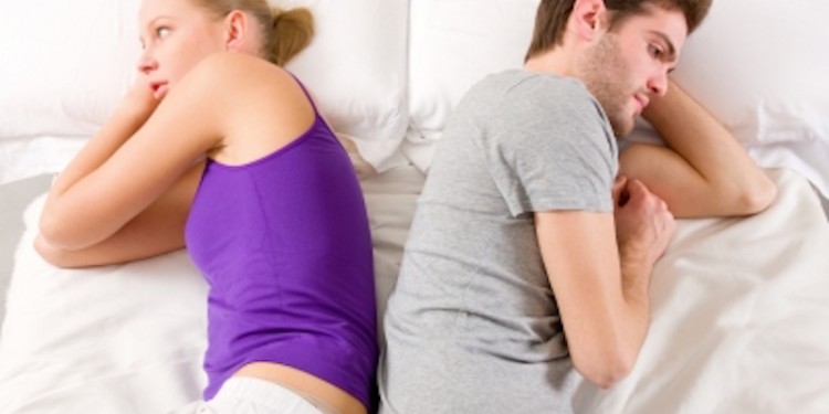Couple Lying In Bed Back-to-Back Stock Photo