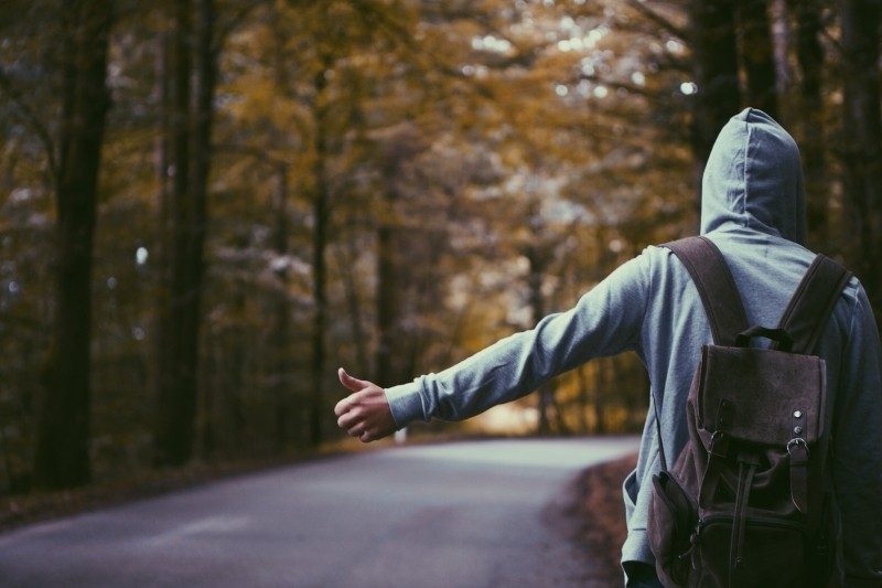 Viaje fora da sua zona de conforto. Isso muda vidas! hitch-hiker-wearing-hood-on-road-in-forest