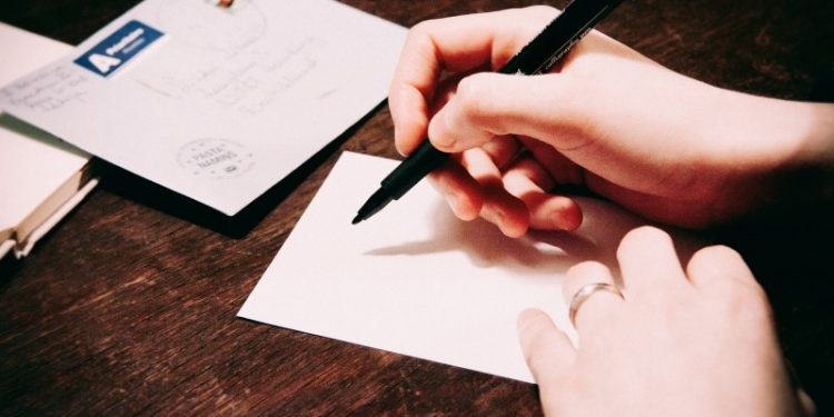 Woman writing postcard