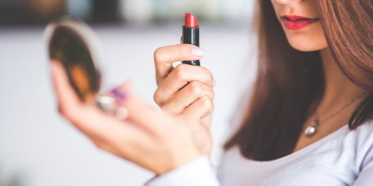 young-woman-applying-red-lipstick
