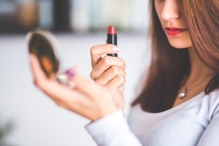 young-woman-applying-red-lipstick